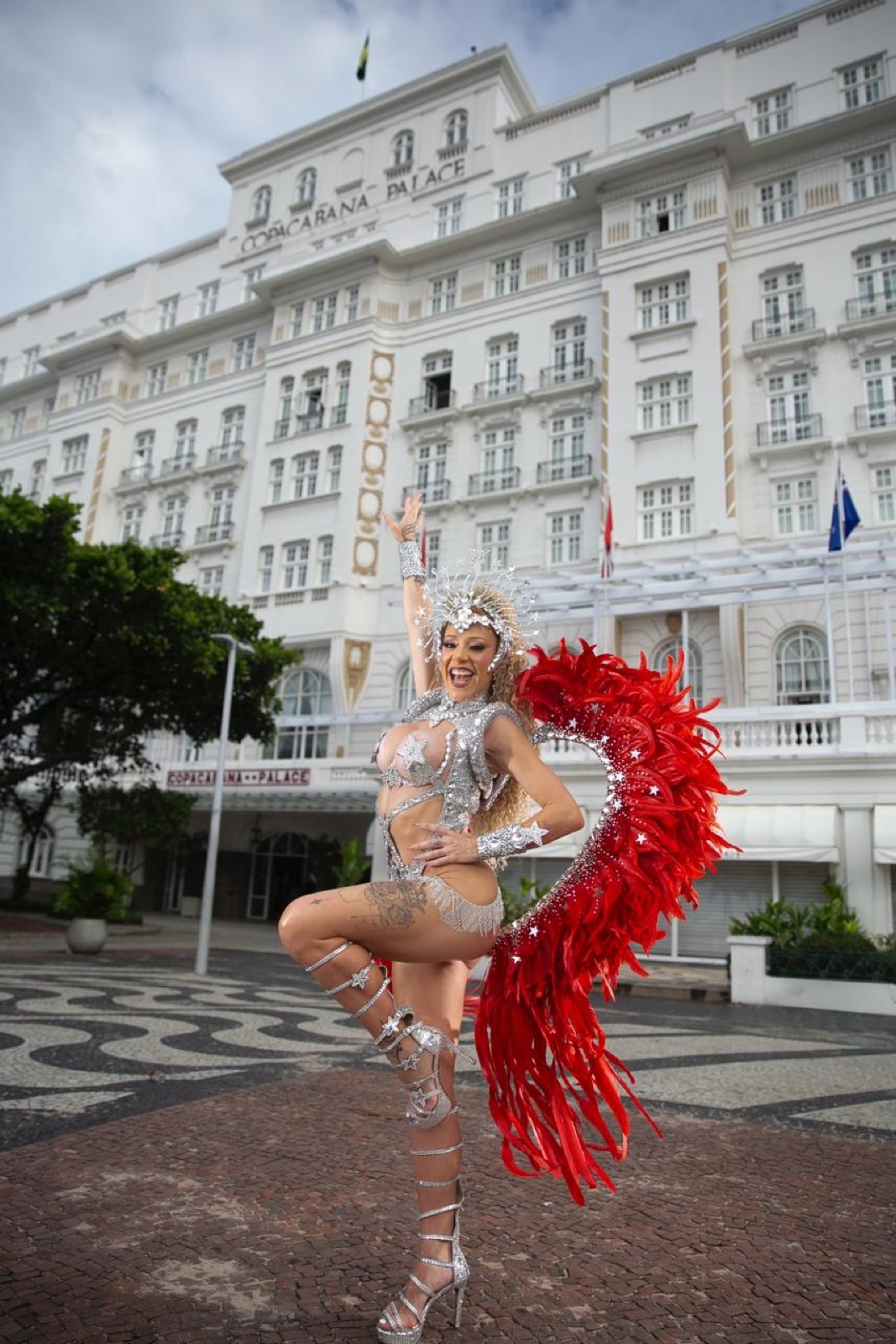 Anna in a silver and red feathered costume outside the Copacabana Palace