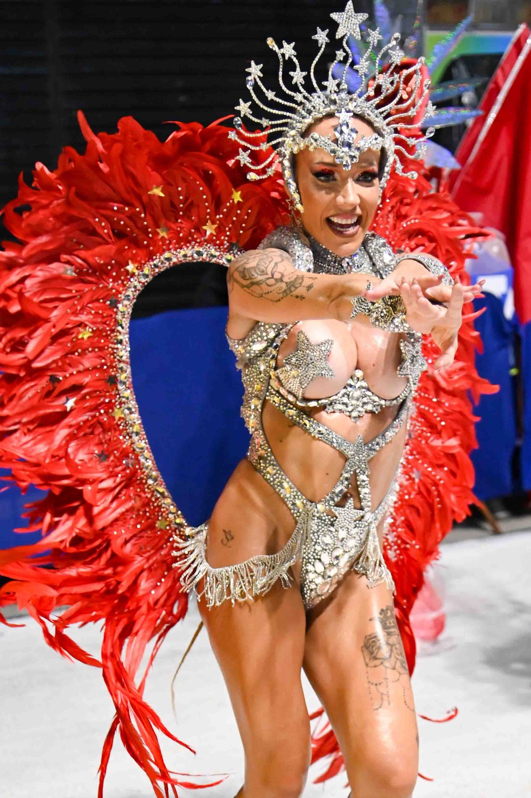 Anna performing in red feathered wings and a crystal costume