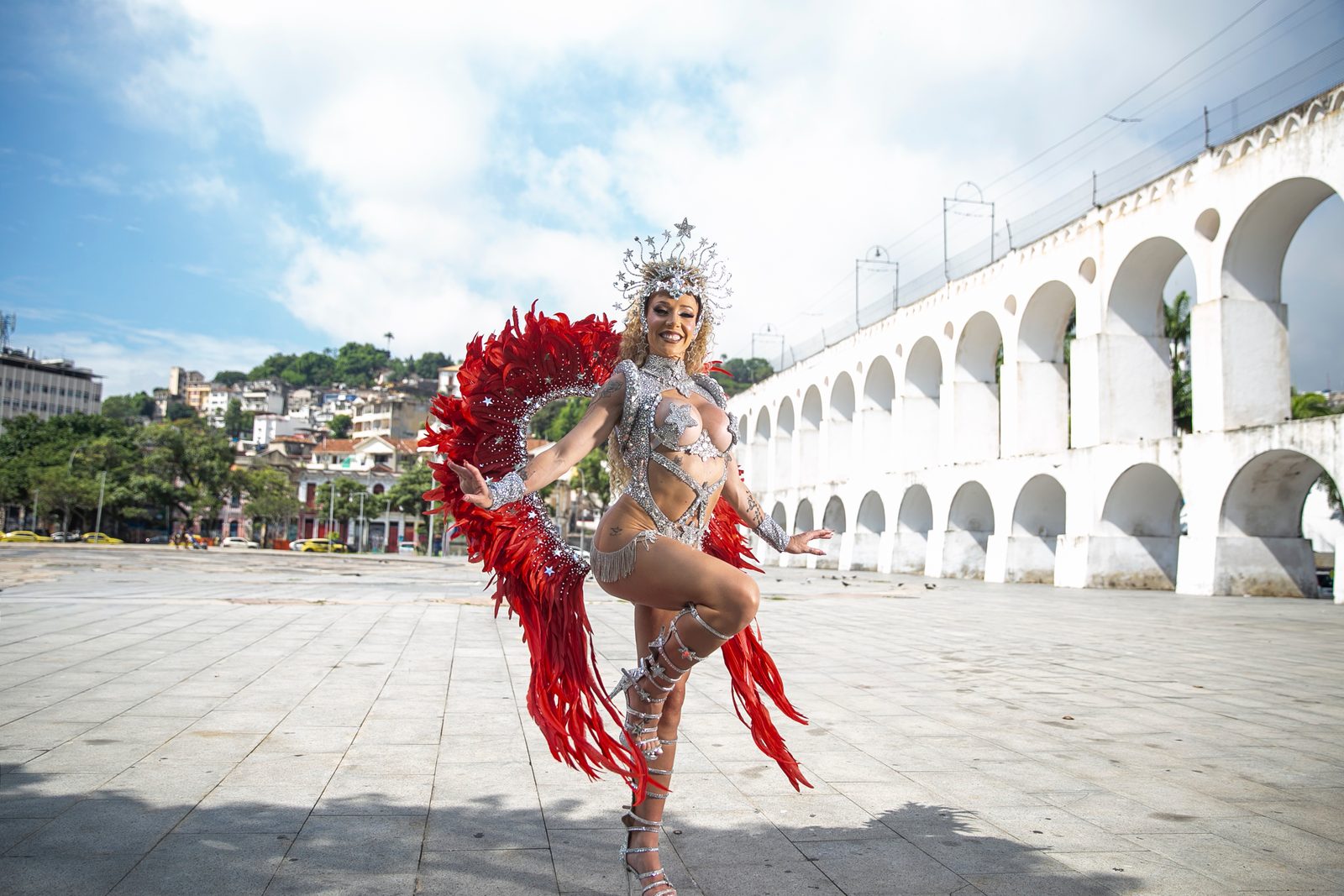 Anna in a red and silver costume posing before the Lapa Arches in Rio de Janeiro