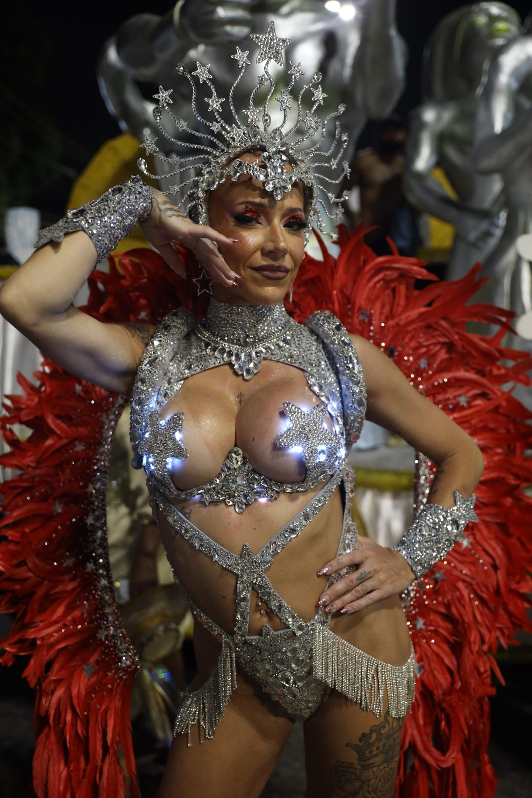 Anna posing on a carnival float in a red and silver costume