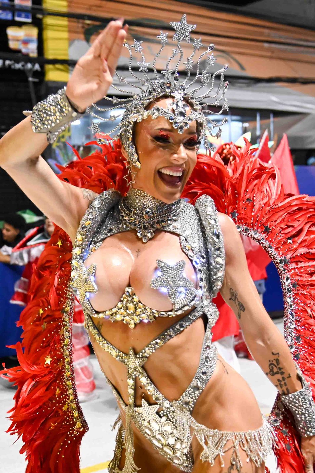 Anna smiling in a silver star crown and red feathers during a parade